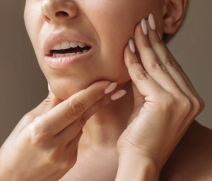 Woman holding onto her jaw in pain